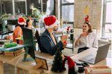 Personas en una oficina con gorros de navidad 