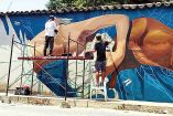 Artistas creando un mural en Oaxaca.