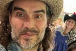 Russell Brand con sombrero sonriendo