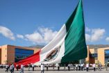 Funcionarios civiles y militares izan la bandera monumental de México durante el acto cívico del mes de abril en la explanada de la Casa del Pueblo, en Guerrero. El evento se realizó bajo un cielo despejado con la participación de la ciudadanía y autoridades estatales