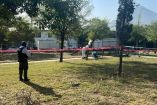 Peritos revisan el cuerpo de un hombre hallado en la banca de un parque
