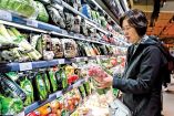 Mujer de nacionalidad China comprando verdura en un supermercado.