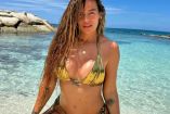 Karol G con bikini dorado y playa atrás