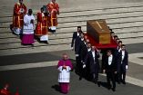 Portadores trasladan el ataúd del papa Francisco durante la ceremonia fúnebre en la Plaza de San Pedro, acompañados por religiosos en vestiduras litúrgicas