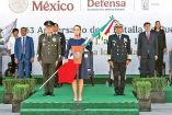 La presidenta Claudia Sheinbaum sosteniendo a bandera mexicana en sus manos.