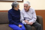 Dos adultos mayores sentados en un sillón