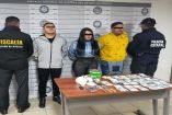 Agentes de la Fiscalía del Estado de México y Policía Estatal presentan a tres personas detenidas por presuntos delitos contra la salud; frente a ellas se observan fajos de billetes, droga y teléfonos celulares decomisados tras un cateo en Bosques de Aragón, Nezahualcóyotl.