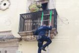 Policías y bomberos suben por el balcón de una casa con ayuda de una escalera