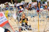 Una mujer, en Tel Aviv (Israel), sostiene carteles con fotos de los cautivos Evyatar David y Rom Braslavski. Foto: AFP
