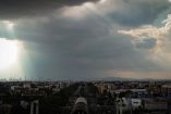 Vista panorámica de la Ciudad de México bajo un cielo cubierto por nubes negras de tormenta, con rayos de sol filtrándose entre las nubes y calles visibles hacia el centro; escena capturada antes de una intensa lluvia que provocó encharcamientos e inundaciones