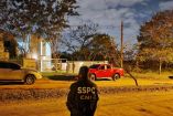Agente de la SSPC y CNI de México de espaldas, observando la residencia donde fue capturado Hernán Bermúdez Requena en Paraguay. La escena muestra varios vehículos frente al inmueble, incluyendo una camioneta roja, y refuerza la cooperación internacional en el operativo nocturno.