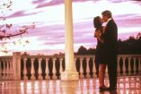 Demi Moore y Robert Redford se besan al atardecer en una lujosa terraza, en una de las escenas más recordadas de Una propuesta indecorosa (1993), ambientada en un entorno elegante y romántico que refleja la tensión emocional de la película.