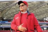 Alfredo Harp Helú en el estadio de los Diablos Rojos con gorra y chamarra del equipo.