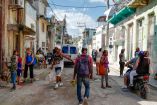Personas de distintas edades se agrupan en una calle del barrio Jesús María, en La Habana, tras una jornada de fumigación por la epidemia de chikunguña. Las condiciones del entorno muestran deterioro urbano, presencia de basura y viviendas en mal estado, reflejo del impacto de la crisis sanitaria y social en Cuba.
