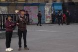 Turistas frente a las vallas metálicas instaladas en el Zócalo de la Ciudad de México, mientras varios elementos de la Policía de la SSC vigilan la zona. Las estructuras están cubiertas de grafitis y forman parte del operativo de seguridad previo a protestas anunciadas por la CNTE y colectivos estudiantiles.