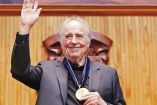 Joan Manuel Serrat, muestra medalla del doctorado Honoris causa que le entregaron en Guadalajara.