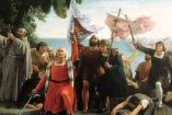 Pintura histórica de 1862 que representa el desembarco de Cristóbal Colón en América en 1492, con estandartes y figuras europeas en la costa, usada como referencia visual sobre la conquista y su interpretación histórica.
