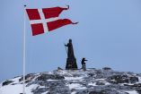 Un hombre camina mientras la bandera danesa ondea junto a la estatua de Hans Egede antes de las elecciones generales del 11 de marzo de 2025 en Nuuk, Groenlandia.