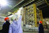 A worker points to the damage of the containment vessel following a drone attack on February 14, 2025, on the New Safe Confinement (NSC) which contains radiation from the remains of reactor 4 of the former Chernobyl Nuclear Power Plant, in Chernobyl, on December 22, 2025, amid the Russian invasion of Ukraine. The Chernobyl Nuclear Power Plant director said on December 23, 2025, fully restoring the internal radiation shelter could take three to four years, after a hit earlier this year punched a hole in the outer radiation shell, triggering a warning from the International Atomic Energy Agency (IAEA) that it had "lost its primary safety functions." And warned that another Russian hit could see the inner shell collapse. (Photo by Tetiana DZHAFAROVA / AFP)