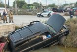 Camioneta Chevrolet Tahoe volcada dentro de un canal pluvial al sur de Matamoros, Tamaulipas, tras un accidente vial; en el lugar se observa la unidad siniestrada y la presencia de autoridades y cuerpos de emergencia.