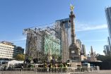 Estructura metálica del escenario para el concierto de música electrónica de fin de año instalada en la glorieta del Ángel de la Independencia, con trabajadores realizando maniobras y vallas de seguridad en Paseo de la Reforma.