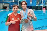 Ma Jin y Osmar Olvera, quien muestra algunas de las medallas que ha ganado.