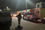Policías estatales caminan y resguardan una calle residencial de Reynosa durante la noche, con patrullas estacionadas y viviendas alrededor, tras un ataque armado registrado en una casa.