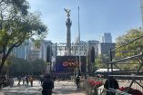 Escenario montado frente al Ángel de la Independencia con pantallas y equipo de sonido, previo al festejo de Año Nuevo, con presencia de personal, asistentes y vallas de seguridad como parte del operativo y los cierres viales en Paseo de la Reforma.