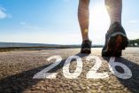 Persona caminando por una carretera con el número 2026 pintado en el asfalto, una imagen simbólica del comienzo de un nuevo año y de la determinación por cumplir objetivos y metas personales a largo plazo.