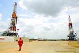 FILE PHOTO: An oilfield worker walks next to drilling rigs at an oil well operated by Venezuela's state oil company PDVSA, in the oil rich Orinoco belt, near Morichal at the state of Monagas April 16, 2015. Picture taken on April 16, 2015. REUTERS/Carlos Garcia Rawlins/File Photo