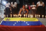 Una mujer encendió una vela junto a una bandera venezolana durante una vigilia para exigir la libertad de los presos políticos en El Helicoide, una instalación y prisión propiedad del gobierno venezolano y utilizada para presos comunes y políticos del Servicio Bolivariano de Inteligencia Nacional (SEBIN), en Caracas el 13 de enero de 2026.