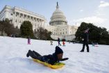 La gente se desliza en trineo frente al Capitolio de los Estados Unidos en Washington, luego de una importante tormenta de nieve.