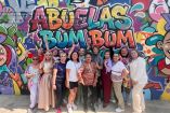 Grupo de mujeres mayores integrantes de Abuelas BUM BUM posan sonrientes frente a un mural colorido con grafiti que lleva el nombre del proyecto en Morelia, como parte de su iniciativa de rap y vejez activa.