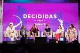 Panel de cinco mujeres participando en el Decididas 2025 Summit, sentadas en escenario con fondo morado del evento, durante un debate sobre liderazgo femenino y desarrollo económico sostenible en la región.