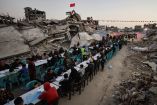 Palestinians gather to break their fast by eating Iftar meals on the first day of the holy month of Ramadan, near the rubble of residential buildings destroyed during the two-year Israeli offensive, in Gaza City, February 18, 2026. REUTERS/Dawoud Abu Alkas