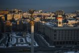Cars drive along Independence Square during sunrise in Kyiv on February 22, 2026, amid the Russian invasion of Ukraine. (Photo by Henry NICHOLLS / AFP)