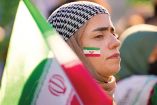 Mujer iraní, usando el hiyab obligatorio, con la bandera de su país.