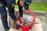 Agente de la Policía de Colombia revisa aros metálicos de baloncesto donde fueron hallados paquetes con cocaína durante una inspección en Bogotá.