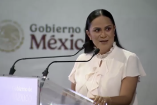 Ariadna Montiel habla en podio transparente con logotipo del Gobierno de México y micrófonos durante acto público sobre programas sociales en Quintana Roo.