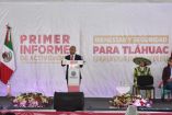 Roberto “Tito” Mejía habla en el estrado durante su primer informe de actividades en Tláhuac, frente a un banner sobre bienestar y seguridad y la bandera de México.