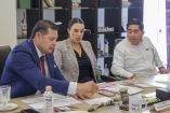 Funcionarios participan en reunión de trabajo sobre la modernización del Aeropuerto Internacional Hermanos Serdán, con documentos y materiales sobre la mesa.