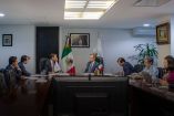 Funcionarios de COFEPRIS y directivos de PiSA Farmacéutica reunidos en sala de juntas con bandera de México durante encuentro institucional.