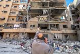 A man points at a building damaged by Israeli strikes, amid escalating hostilities between Israel and Hezbollah, as the U.S.-Israeli conflict with Iran continues, in Beirut's southern suburbs, Lebanon, March 28, 2026. Picture taken with a mobile phone. REUTERS/Stringer     TPX IMAGES OF THE DAY