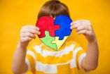 Kid boy hands holding puzzle heart, child mental health concept, world autism awareness day, teen autism spectrum disorder awareness concept