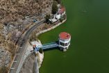 Vista aérea de presa del Sistema Cutzamala con torre de captación, camino perimetral y nivel de agua visible en temporada de estiaje