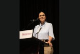 Ariadna Montiel Reyes habla en un podio con logotipo de Bienestar durante un evento oficial, frente a micrófono en escenario interior