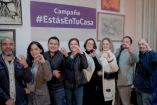 Grupo de anfitriones de estancias turísticas posa frente a cartel de la campaña #EstasEnTuCasa durante presentación en Ciudad de México