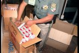 Un policía, con cajas decomisadas de cigarros de contrabando.