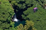 Cabina del teleférico de Uruapan cruza sobre vegetación densa y una cascada en la Barranca del Cupatitzio en Michoacán