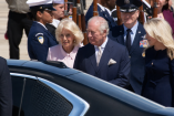El rey Carlos III y la reina Camila descienden de un vehículo oficial en Washington, rodeados por personal militar durante su visita de Estado.